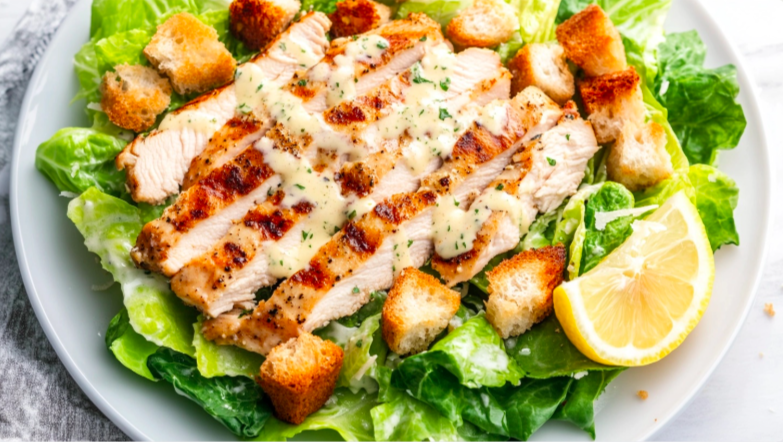 Freshly prepared Chicken Caesar Salad with grilled chicken and croutons.